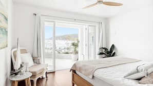 Un dormitorio con cama, una silla, una mesa y un ventilador de techo.