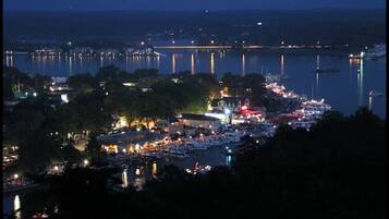 Eine Stadt am Wasser bei Nacht mit beleuchteten Gebäuden und Booten.