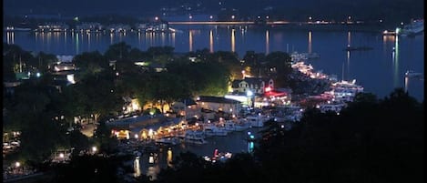 A waterfront town at night with illuminated buildings and boats.