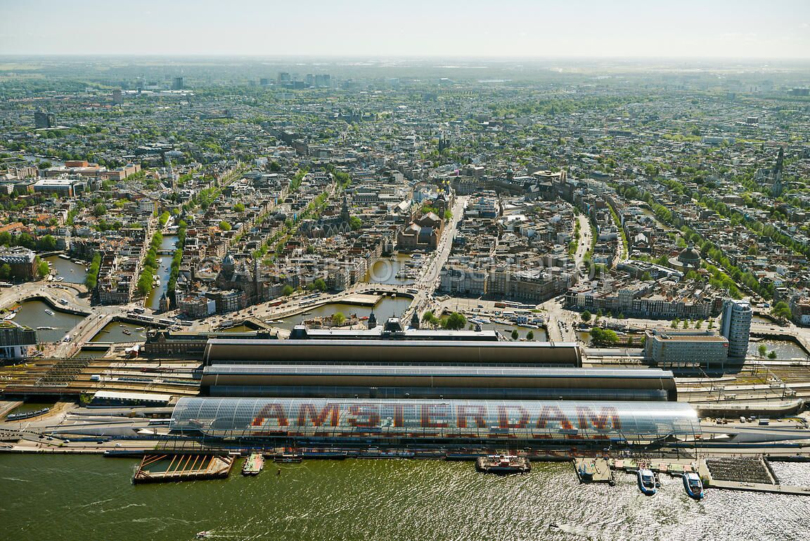 An aerial view of a city with a large, modern train station and a river running through the center.