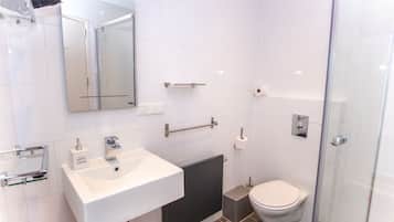 Une salle de bain moderne avec un lavabo blanc, un miroir et des toilettes.
