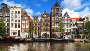 A canal-side view of historic buildings with a clear sky.