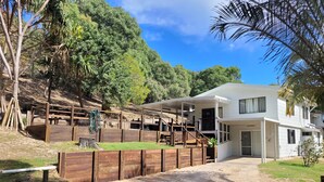 A modern two-story house with a covered outdoor area, surrounded by natural landscape and trees. - Lil's Place - Happy Valley - K'gari (Fraser Island) (Fraser Island)