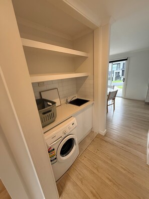 A laundry room with a washing machine, a sink, and a drying rack. - Miss McCrae walk to everything!!!! (McCrae)