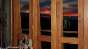 Une pièce avec des fenêtres à cadre en bois, une tringle à rideaux visible et un store.