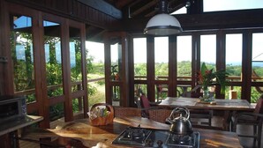 Une terrasse en bois avec une table et des chaises, une bouilloire, un panier et un réchaud.