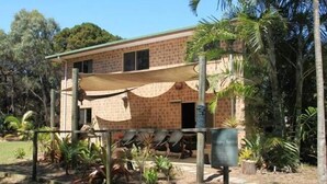 A two-story building with a brick facade and a covered patio area. - K'GARI (FRASER ISLAND) My Island Home. Sleeps 14. Situated in Eurong  (Eurong)