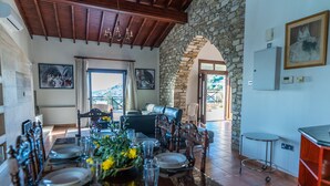 Comedor con arco de piedra, techo de madera y vistas al exterior.