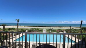 A pool with a view of the beach and ocean.