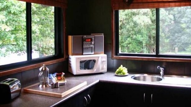 A compact kitchen with a microwave, toaster, and a small sink.
