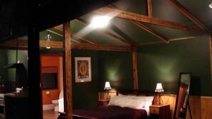 A room with a bed, two bedside tables with lamps, a mirror, and a framed picture on the wall.
