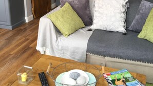 Un dormitorio con cama, mesita de noche, lámpara y un cuadro floral en la pared.