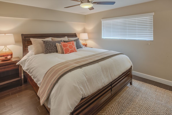 A bedroom with a wooden bed, two bedside tables with lamps, a ceiling fan, and a window with blinds. - Room for Everyone, Block from the Beach (Pismo Beach)