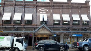 A building with a sign reading "Springett's Arcade 1926" and a storefront with a blue awning.