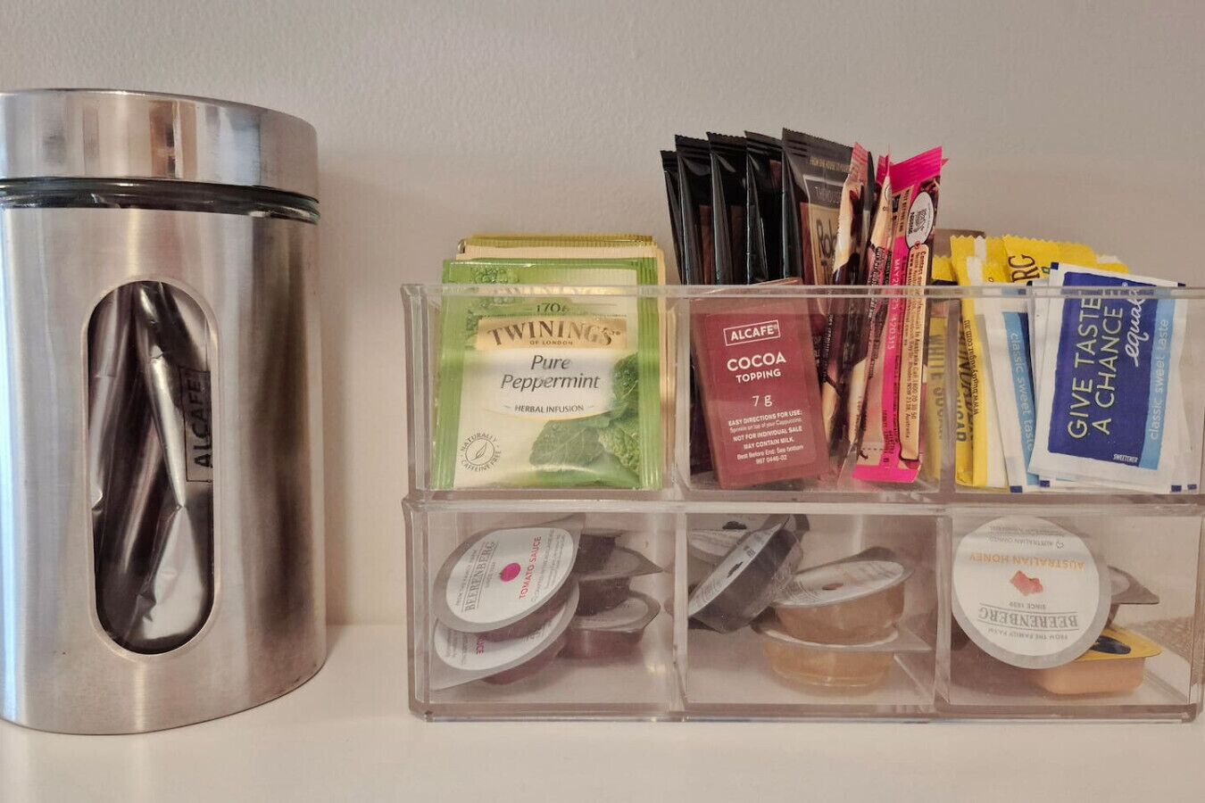 A stainless steel kettle, a set of infuser bottles, and a variety of tea bags and sachets.