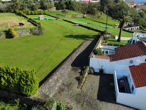 Surrounded by lush greenery, this serene residential area features a well-maintained lawn and a stone wall.