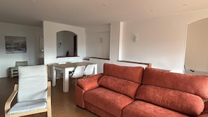 A modern living room with a sofa, a dining table with chairs, and a kitchen area. - NEGURI METRO (BILBAO-GUGGENHEIM) - Ideal Families, WIFI  (Getxo)
