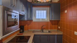 Une cuisine moderne dotée d’appareils électroménagers en acier inoxydable, d’un four encastré, d’une plaque de cuisson et d’une fenêtre située au-dessus de l’évier.