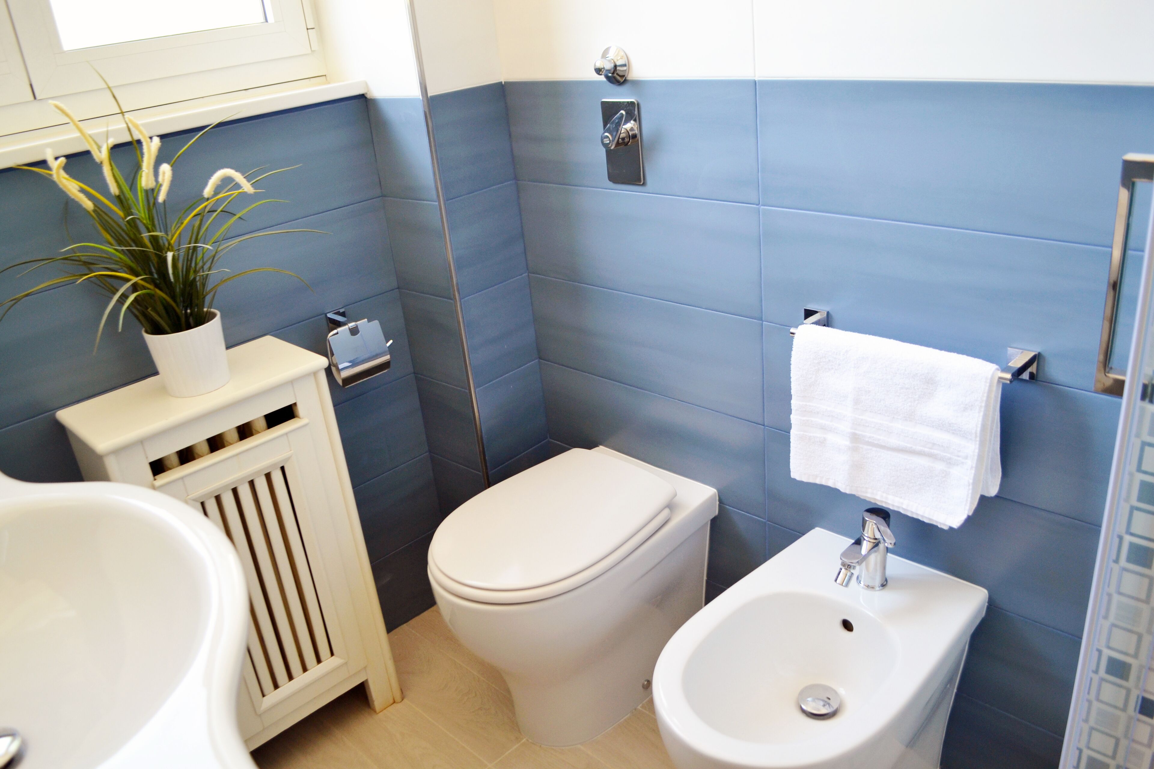 A bathroom with a toilet, bidet, and a sink.
