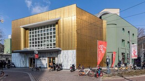A modern building with a large glass facade, a wooden exterior, and a sign for a cinema and theater. - Relax and stand a few steps away from the city center (Milano)