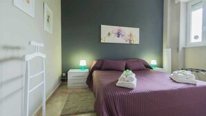 A bedroom with a bed, two bedside tables, a wall-mounted lamp, and a framed floral artwork. - Relax and stand a few steps away from the city center (Milano)