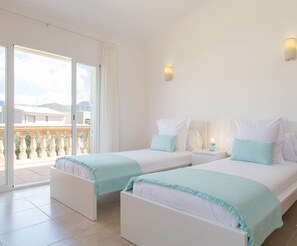 Une chambre d’hôtel avec deux lits, un balcon et une vue sur la ville.