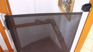 Ein Zimmer mit Schiebetür, Fliesenboden und einem gerahmten Bild an der Wand.