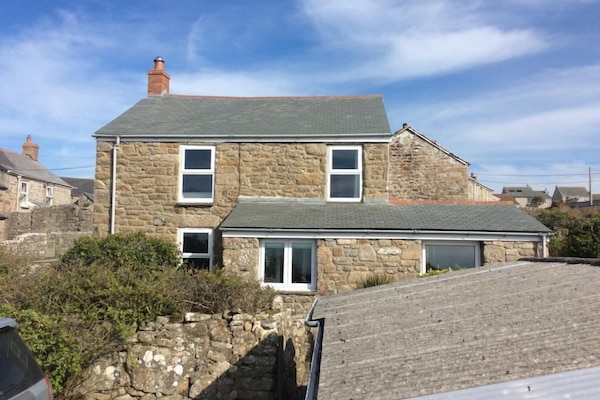 Front of the cottage. Kitchen bottom right. Bedroom top left.
