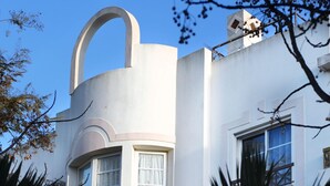 A modern building with a curved architectural feature, large windows, and a visible satellite dish.