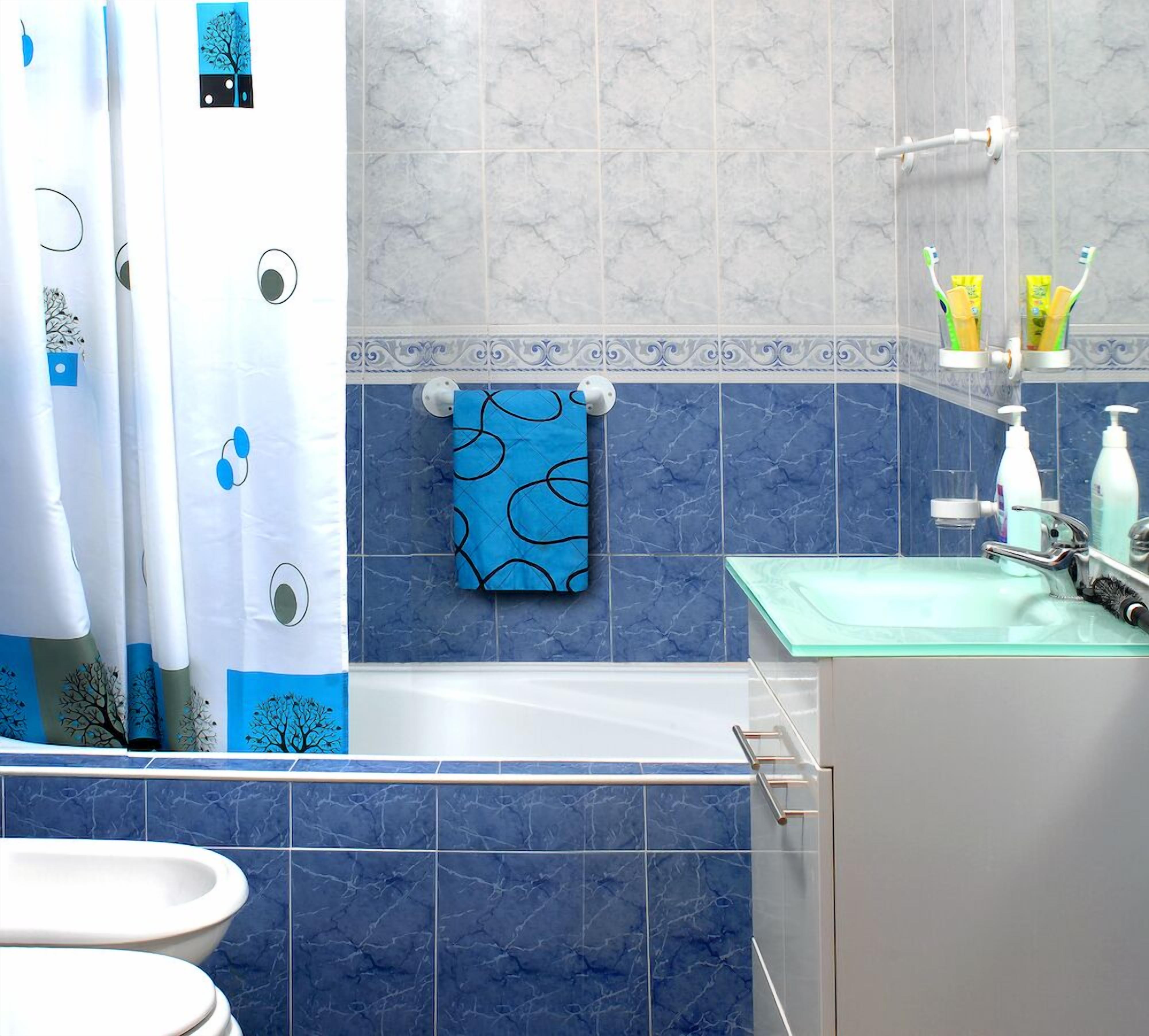 Un baño con bañera, inodoro y lavamanos.