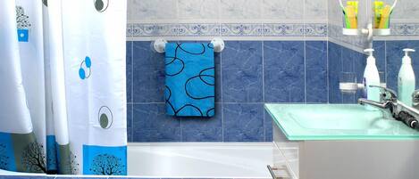Un baño con bañera, inodoro y lavamanos.
