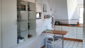 Eine moderne Küche mit weißen Schränken, einem Holzespeisetisch und einer gefliesten Spritzschutzwand.