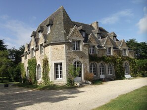 A large stone building with multiple windows and a gravel driveway. - Large house in private park, walking distance to the sea, sleeps 15 (Tréflez)