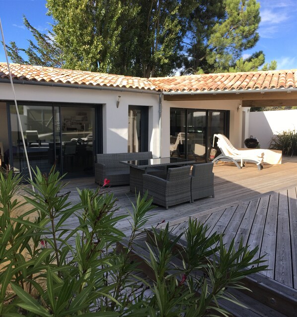A patio area with outdoor furniture, a pool, and a covered seating area.