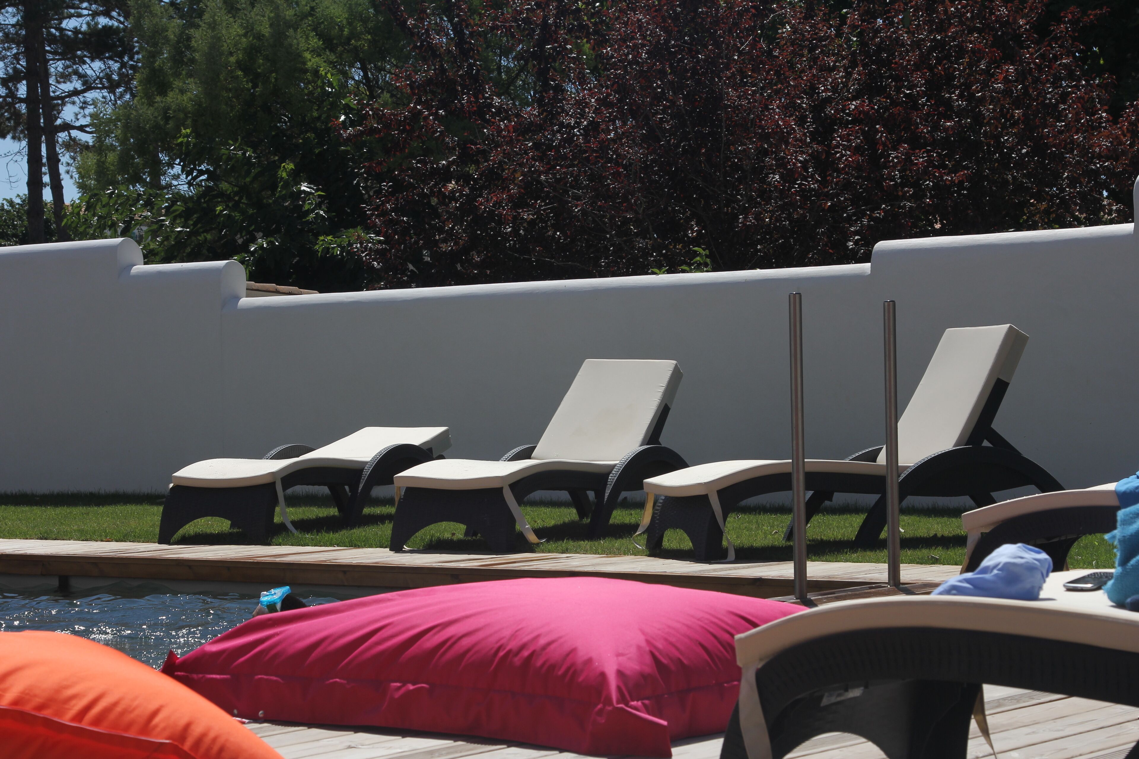 Area piscina con lettini e un pontile in legno.