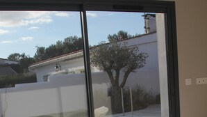 Quarto com uma grande porta de vidro deslizante que dá para um pátio externo.