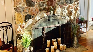 A stone fireplace with a white mantel, surrounded by candles, a framed sign, and decorative items. - Lake Michigan Home with gorgeous views, great spot for family or golf retreat (Sheboygan)