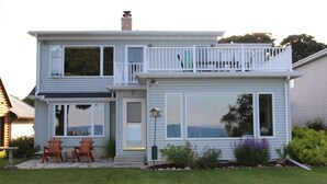A two-story house with a balcony, large windows, and a well-maintained lawn. - Lake Michigan Home with gorgeous views, great spot for family or golf retreat (Sheboygan)