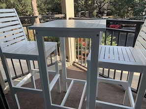 Relax in a serene outdoor space with a small table and two chairs.
