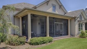 A two-story house with a covered porch and a screened-in area.