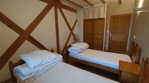 Una habitación con dos literas de madera, un armario de madera y una puerta de madera.