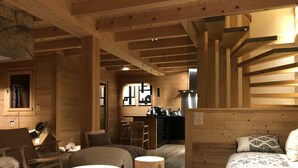 Een gezellig houten blokhutinterieur met een eethoek, keuken en zithoek.