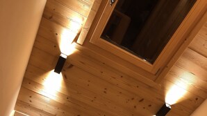 Een houten plafond met zichtbare balken en een dakraam.
