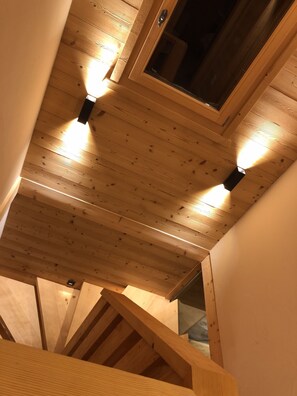 A wooden ceiling with exposed beams and a skylight.