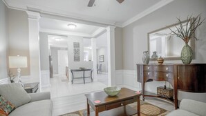 Una sala de estar con un sofá, una mesa de centro y un mueble de madera con espejo.