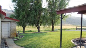 A residential property with a well-maintained lawn, a garage, and a covered outdoor area.