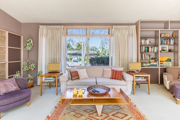 A living room with a sofa, coffee table, and a bookshelf.