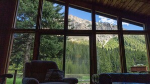 Une pièce dotée de grandes fenêtres donnant sur un paysage montagneux.