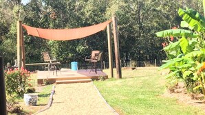 A patio area with two chairs, a small table, and a blue trash bin. - Cottage. 3 bedrooms, 2 baths and full kitchen on sheep and goat farm  (Jefferson)