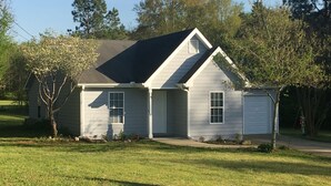 A single-story house with a gabled roof, a front porch, and a garage. - Cottage. 3 bedrooms, 2 baths and full kitchen on sheep and goat farm  (Jefferson)